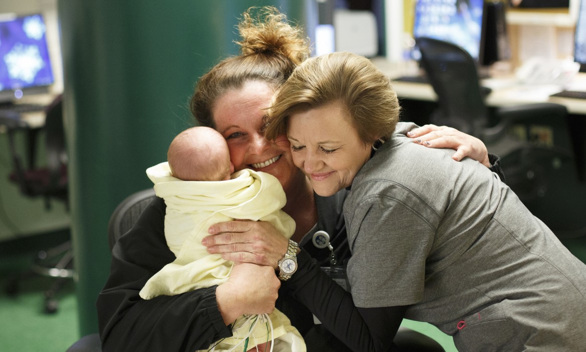 Sheri Smith, RN and Critical Care Services Director at East Tennessee Children's Hospital in Knoxville, TN, visits with Deborah Valentine as she cares for a baby at the nurses station.