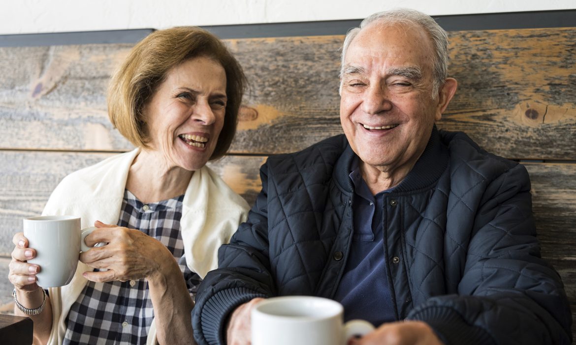 Senior couple smiling having a cup of coffee in a coffee shop