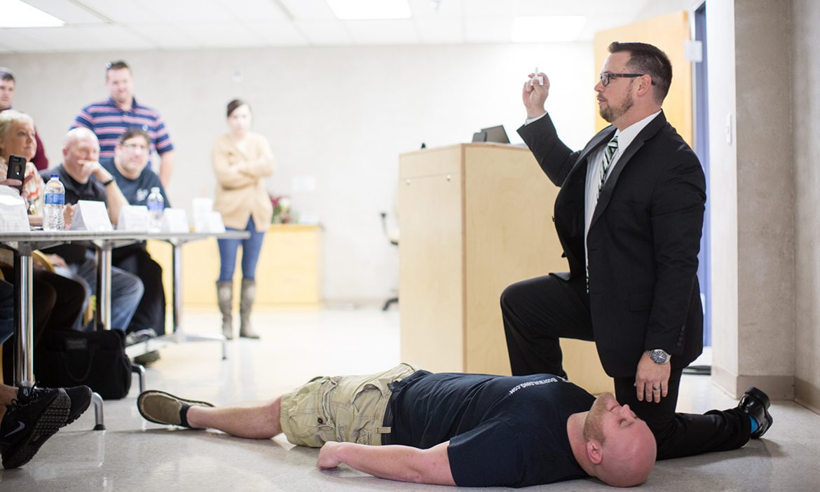 a teacher demonstrates the successful administering of Narcan
