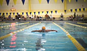 senior olympian swimming in pool